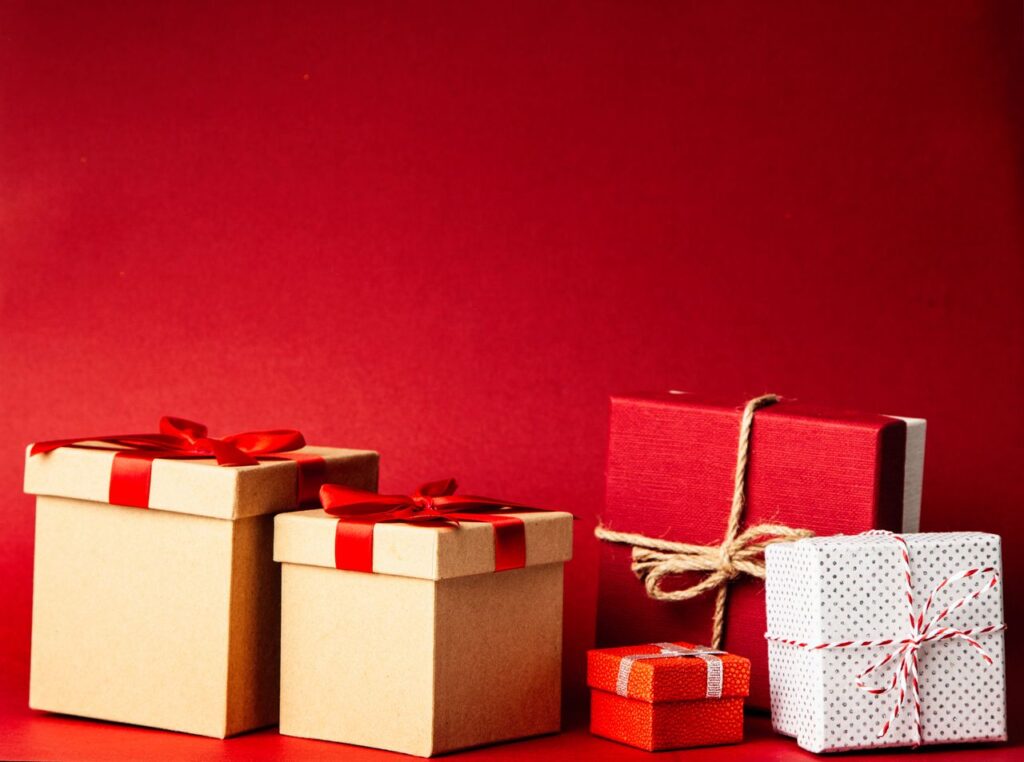 The Art of Drawing Readers In: Your attractive post title goes here A collection of colorful gift boxes with ribbons on a rich red background, perfect for holiday themes.